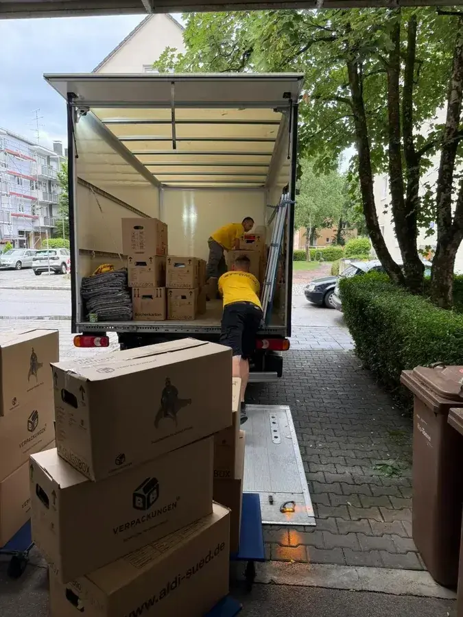 Zwei Umzugshelfer beim Verladen am LKW