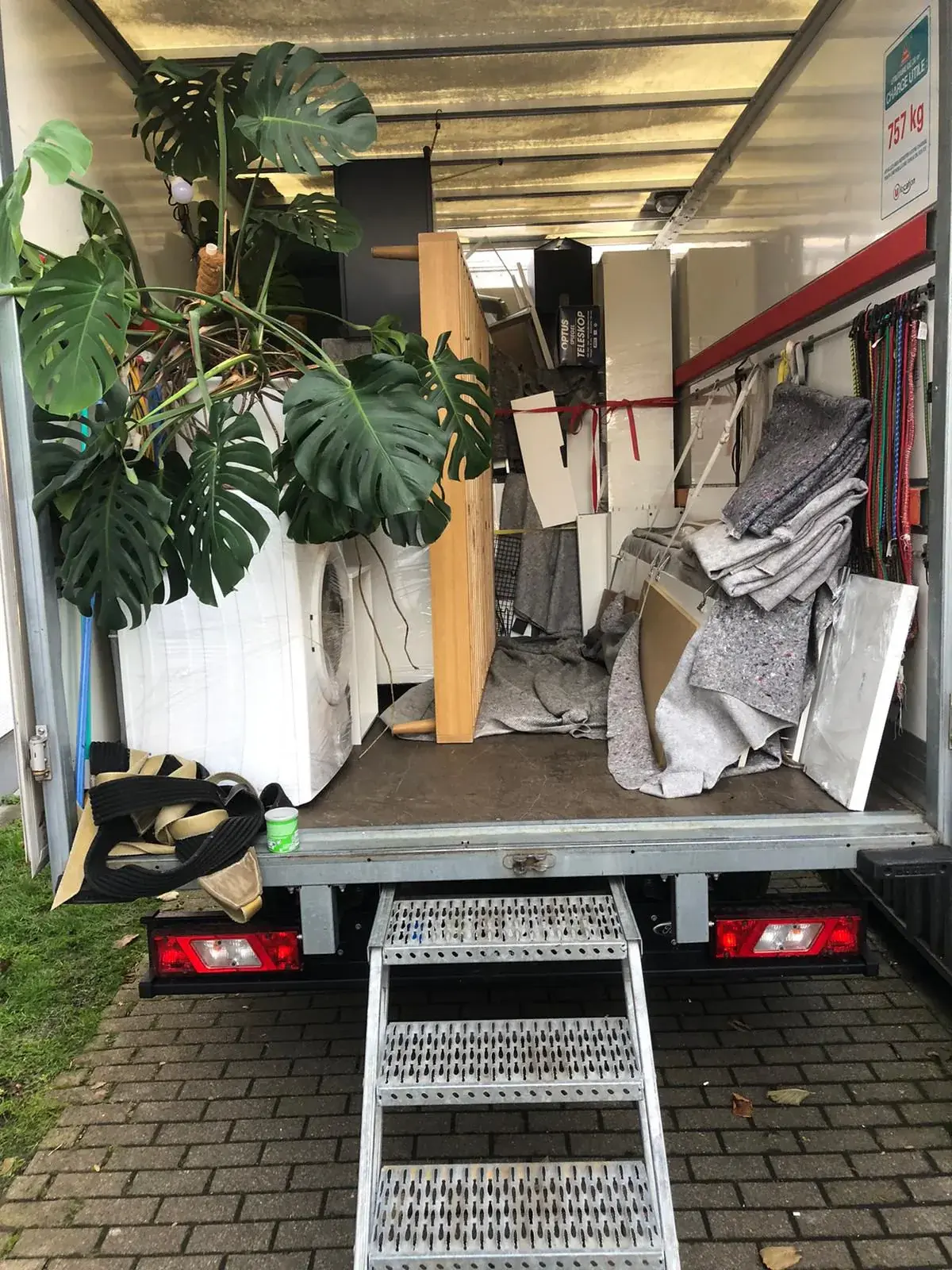Beladener Umzugstransporter mit Möbeldecken, Stretchfolie und Spanngurten